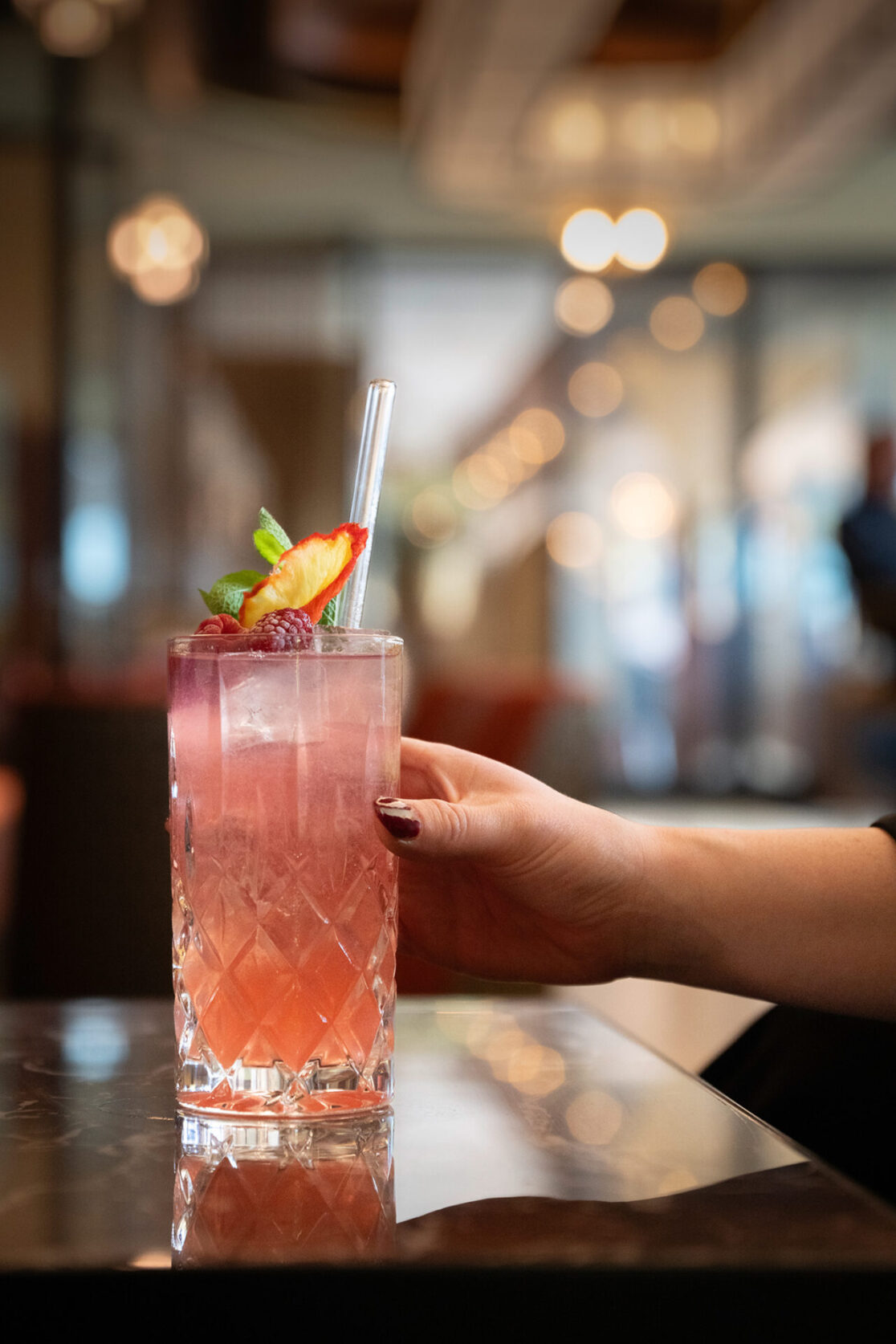 Eine Hand greift nach dem Cocktail in der DOX Bar im Hyatt Regency Düsseldorf