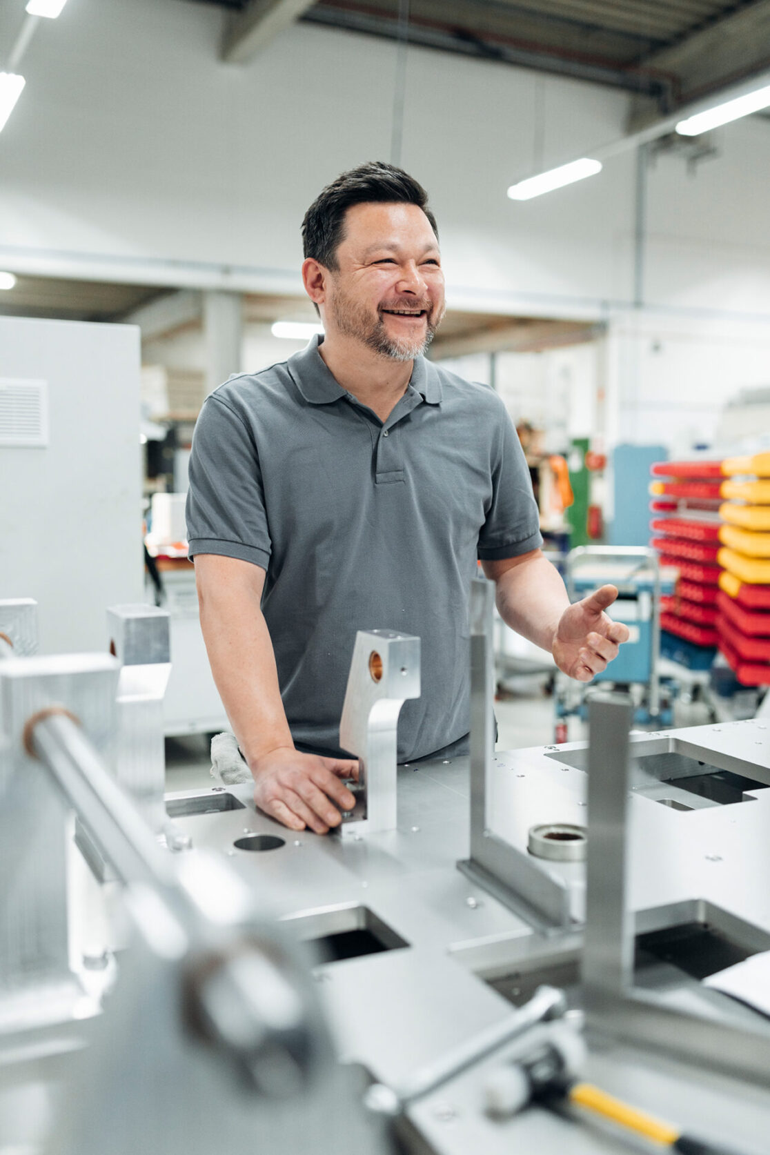 Businessreportage Rasch Verpackungsmaschinen Köln - Mitarbeiter steht an den Einzelteilen einer Verpackungsmaschine